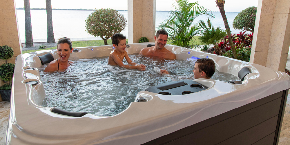 Family enjoying time together in a hot tub playing in the water.